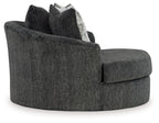 Dark gray oversized swivel accent chair with armrests and two stacked geometric pillows