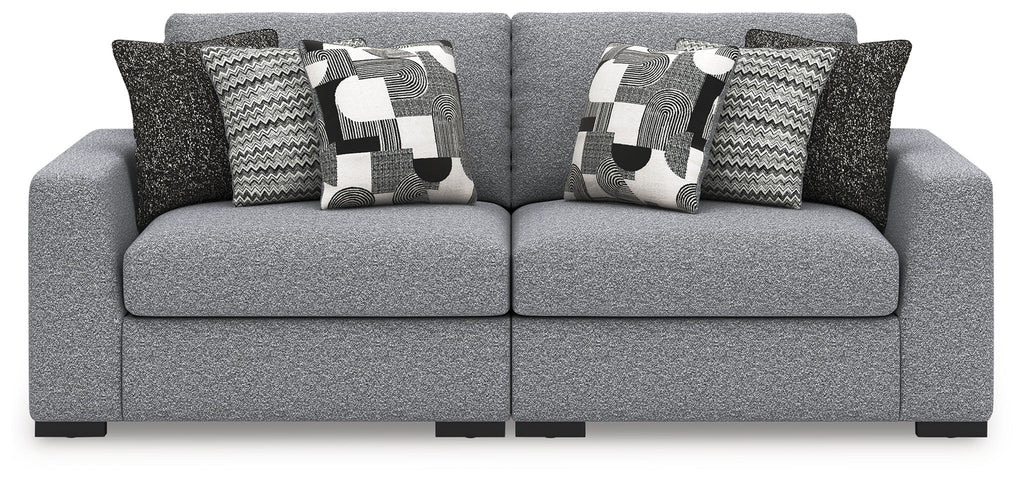 Loveseat sofa in light gray with patterned pillows and dark accent pillows