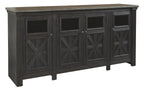 Black TV stand with gray top and four cabinet doors featuring X-pattern panels