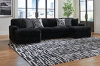 Black corded sectional sofa with chaise and gray patterned throw pillows