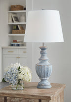 Antique blue table lamp on wood table with white fabric shade