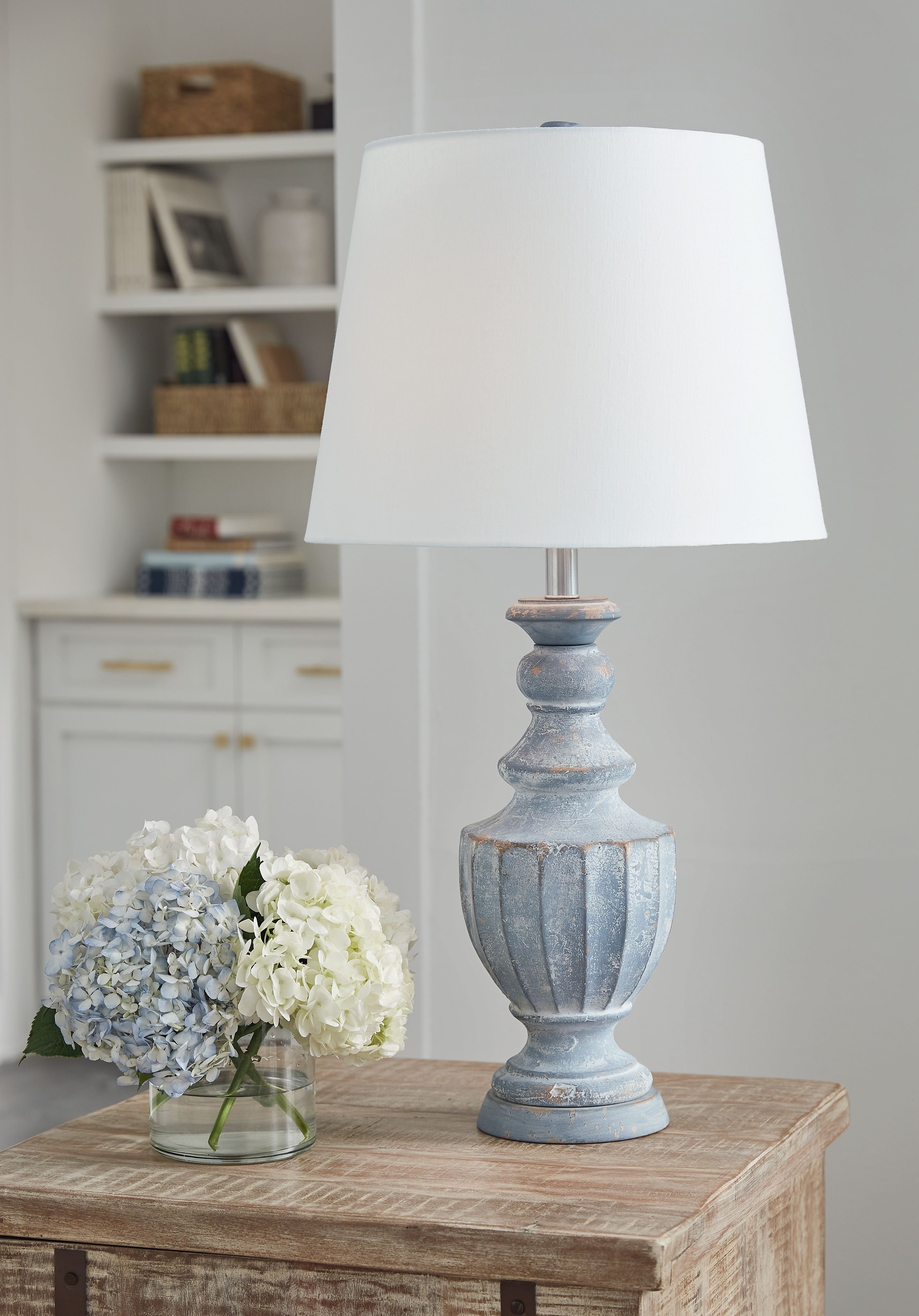 Antique blue table lamp on wood table with white fabric shade