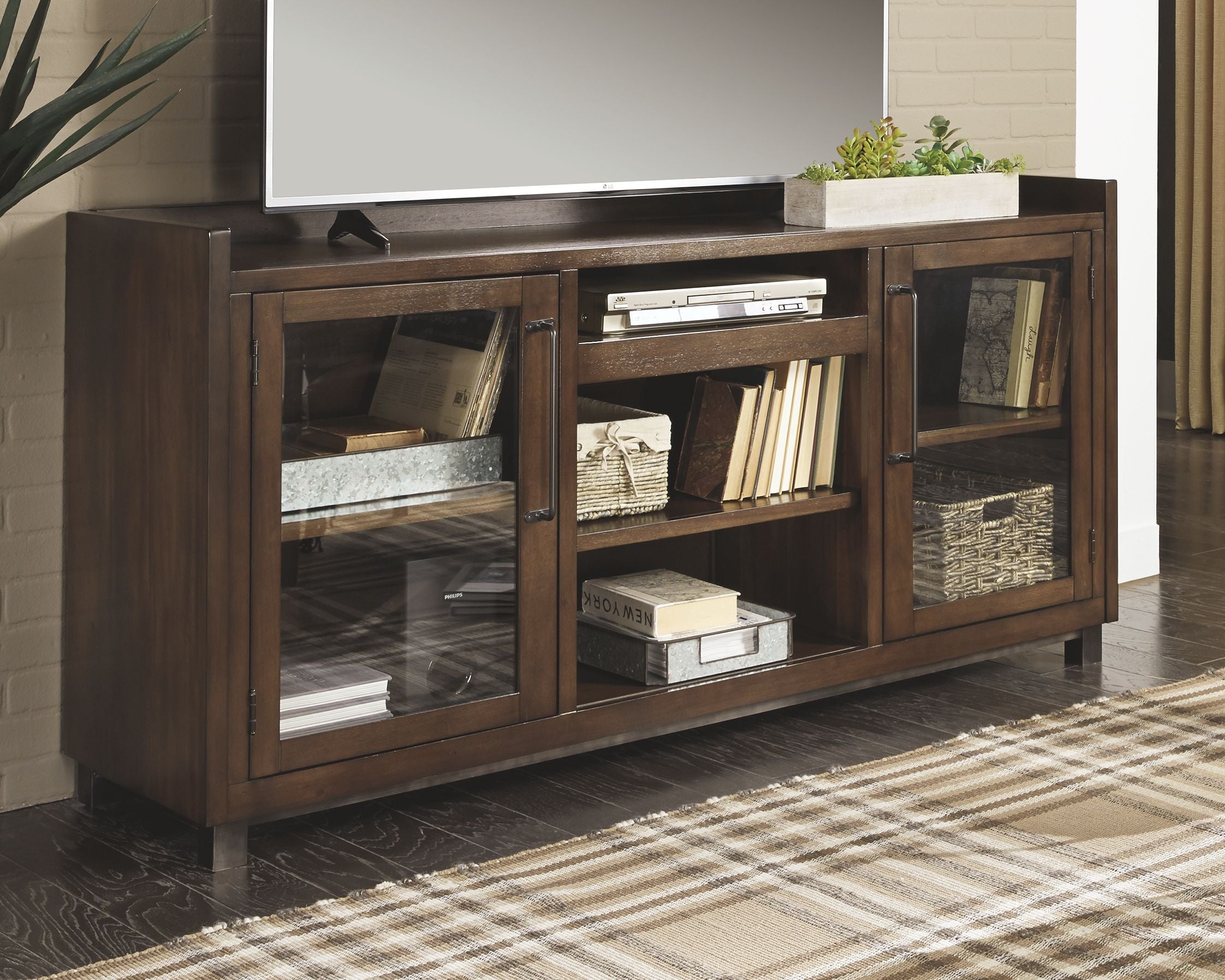 Brown wood TV stand with inset-panel cabinet doors and open central shelving