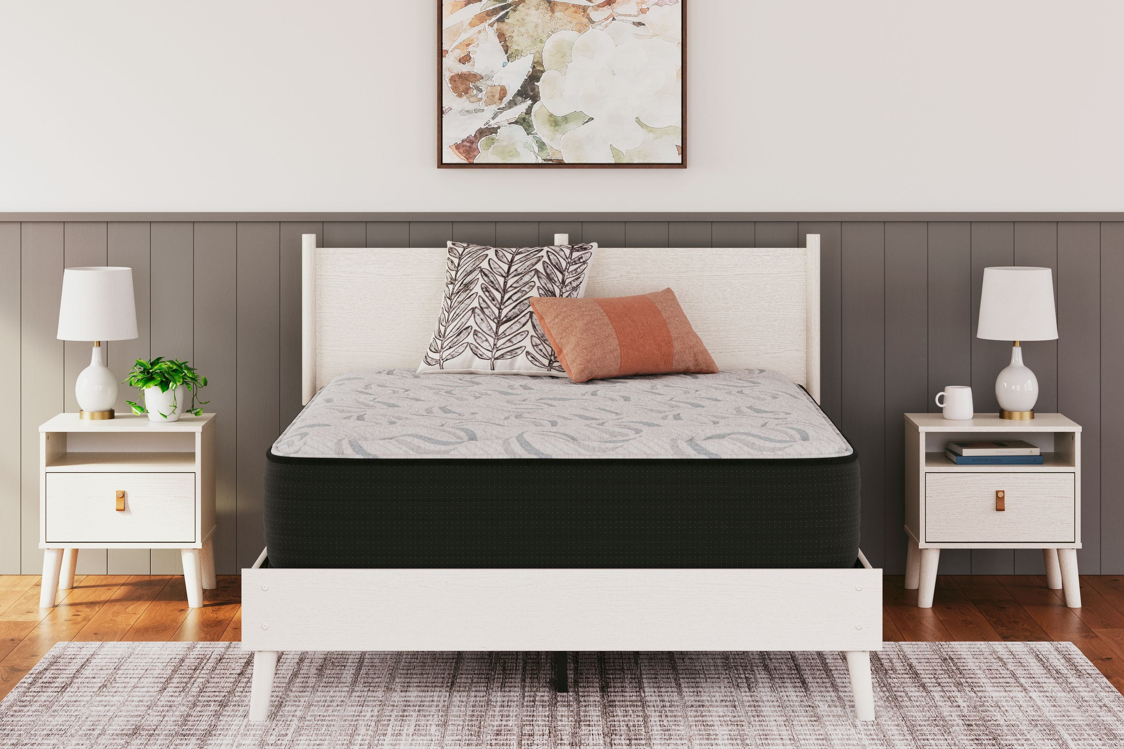 Plush gray mattress on a dark base with patterned cover and pillows