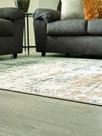 Light gray and teal abstract area rug under a gray sofa