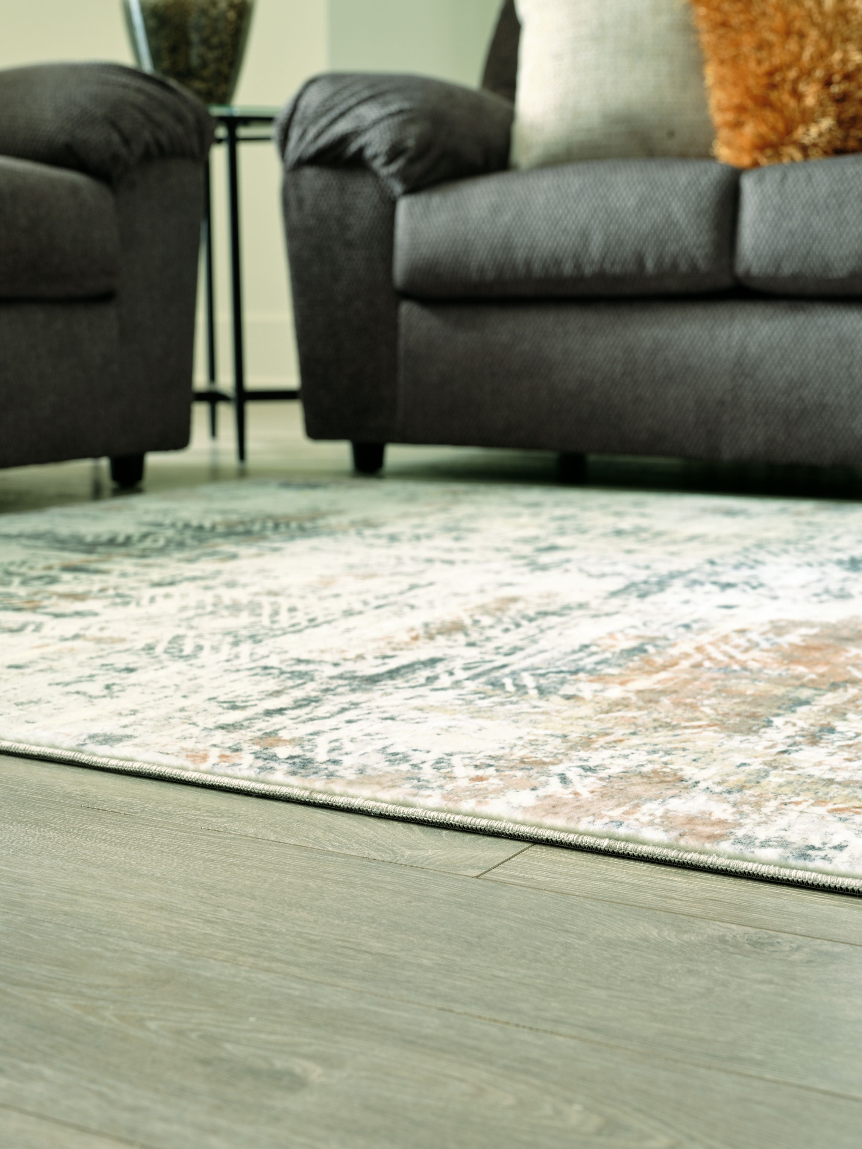 Light gray and teal abstract area rug under a gray sofa