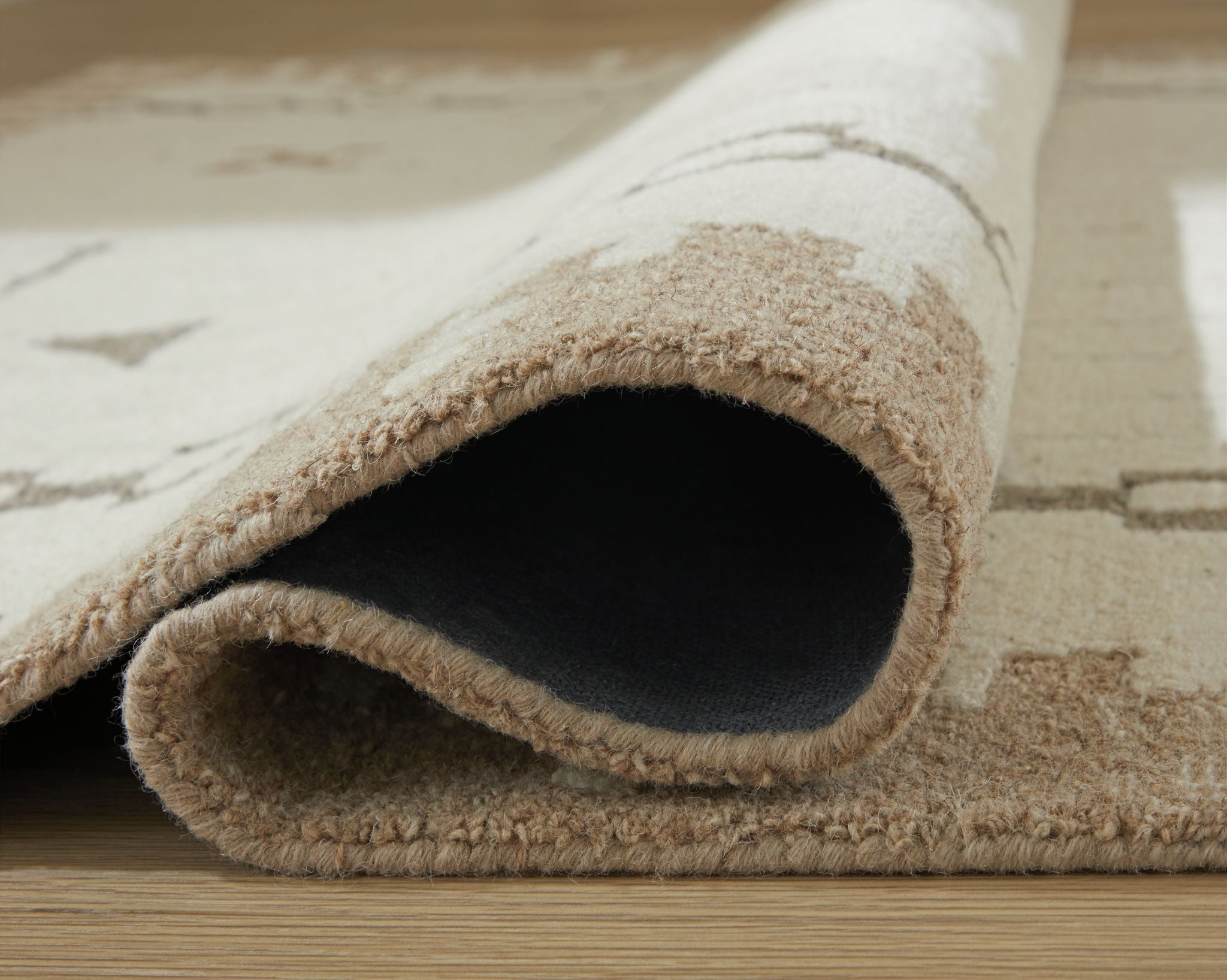 Light brown area rug with folded edge and beige shaggy texture