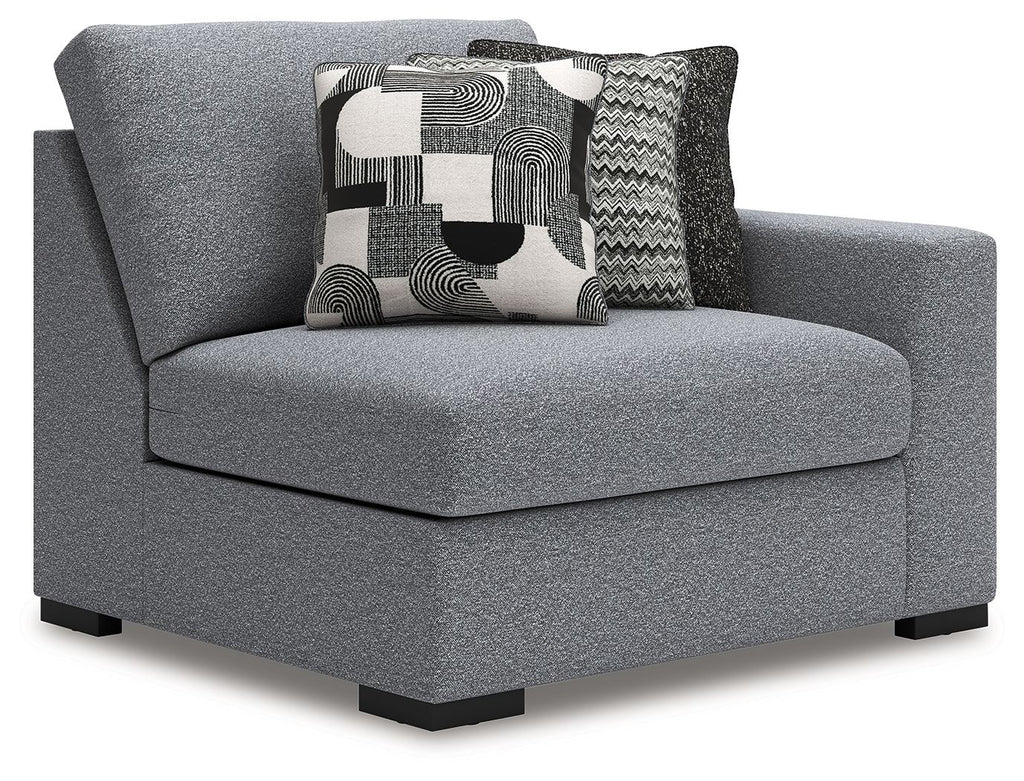 Gray upholstered chaise corner chair with rounded back and large patterned back pillow