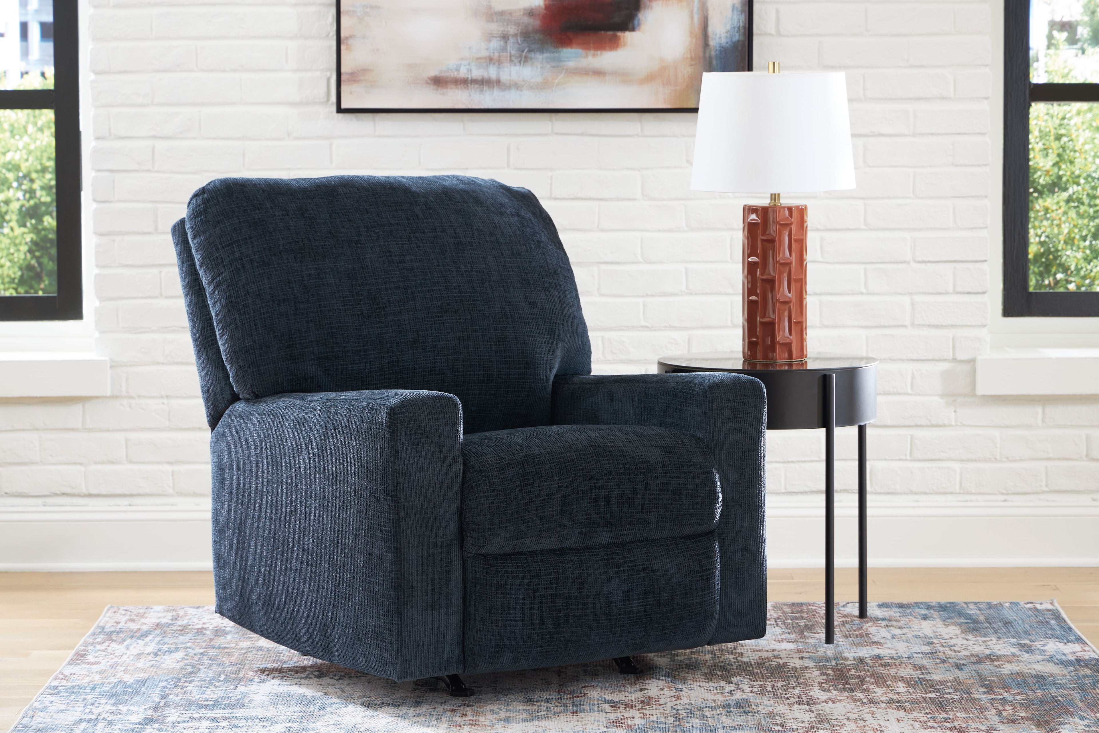 Rocker recliner chair in dark blue with padded armrests and curved backrest