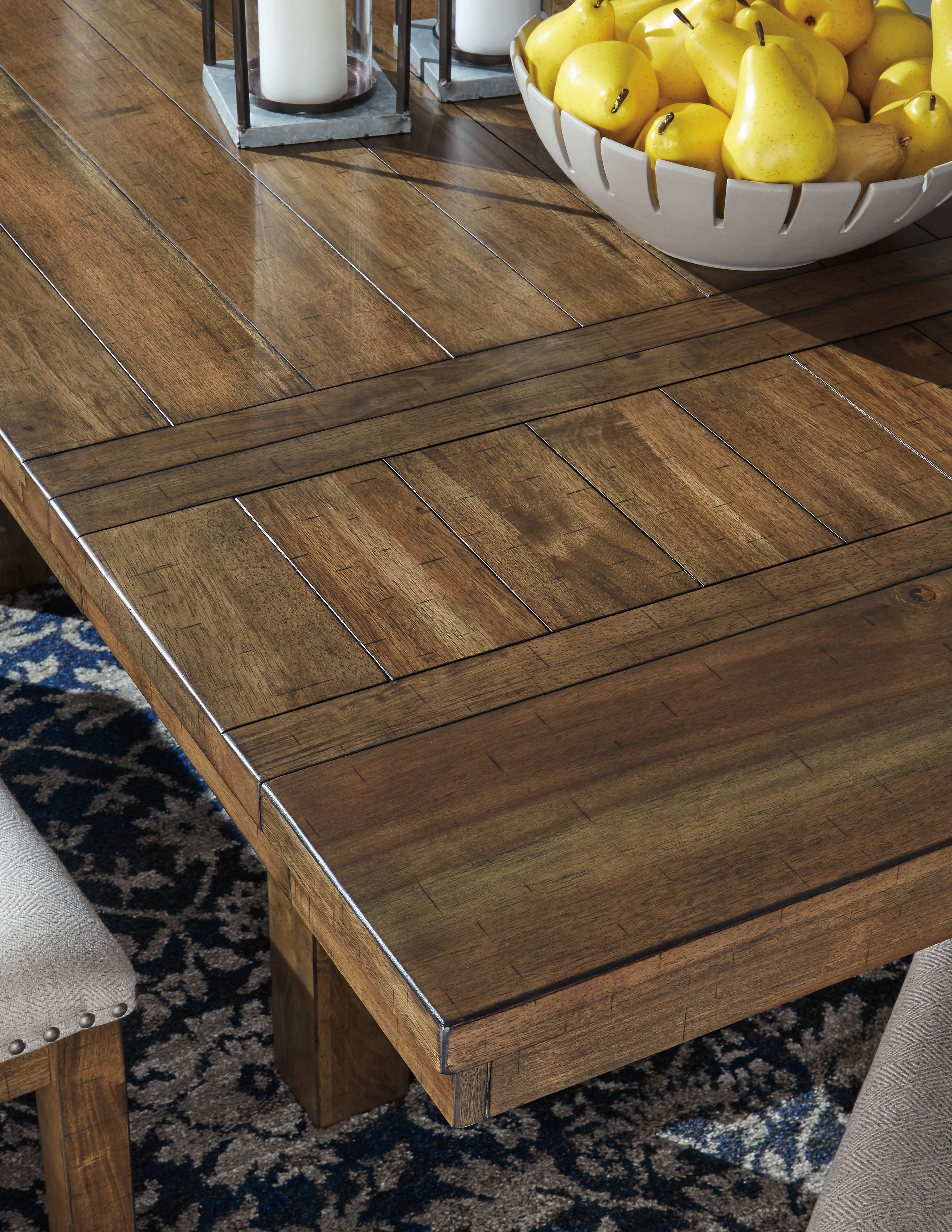 Close-up of grayish brown plank dining table top with beveled edges and corner trim