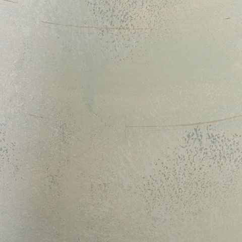 Cream speckled glaze close-up on ceramic vase with subtle seam lines.