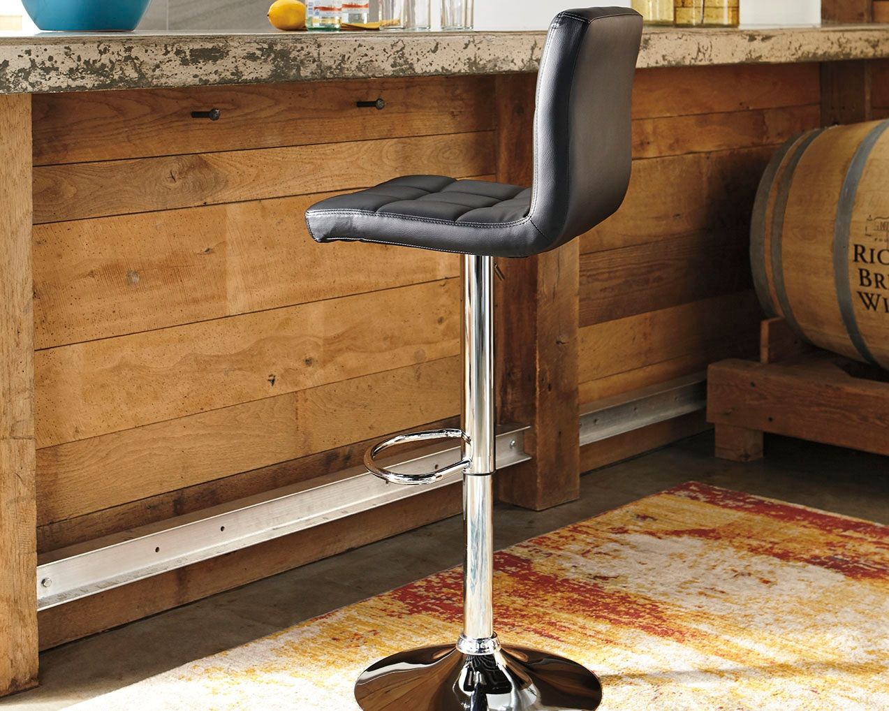 Black adjustable barstool with tall back, chrome pole and round base with footrest