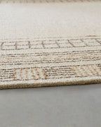 Beige rug edge with stitched geometric border pattern