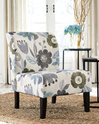 Accent chair with blue-gray floral upholstery and dark wooden legs, upholstered arms.