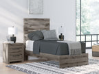 Dark gray panel bed frame with white mattress and gray throw blanket
