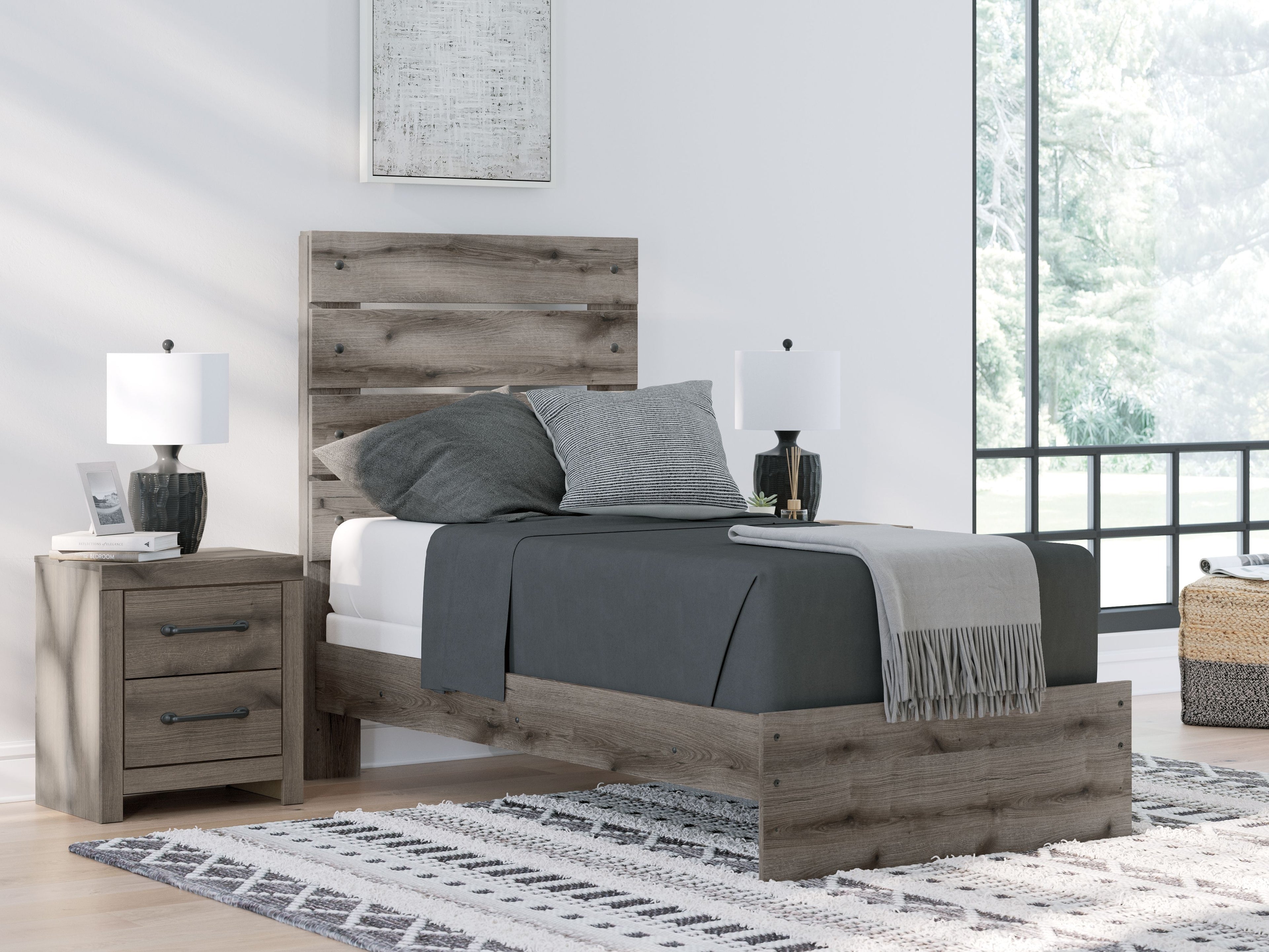 Dark gray panel bed frame with white mattress and gray throw blanket