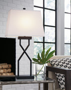 Black metal table lamp with white fabric shade and cross X-shaped support base