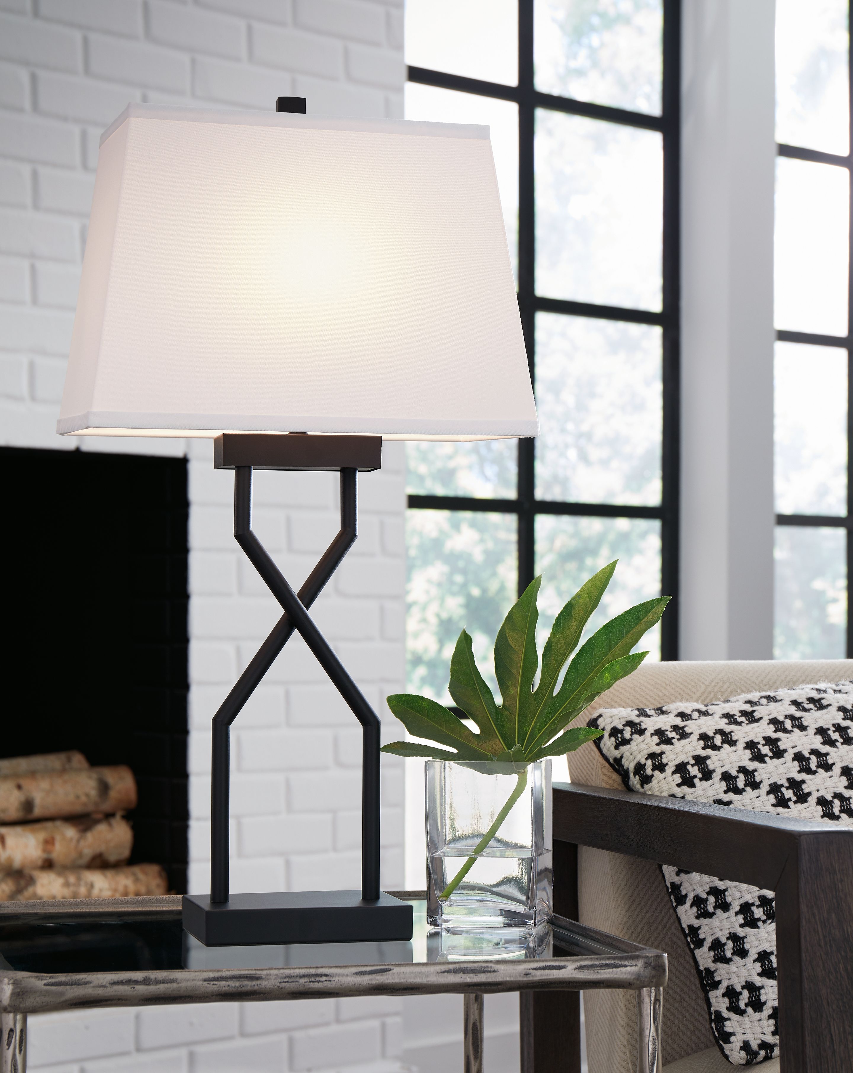 Black metal table lamp with white fabric shade and cross X-shaped support base