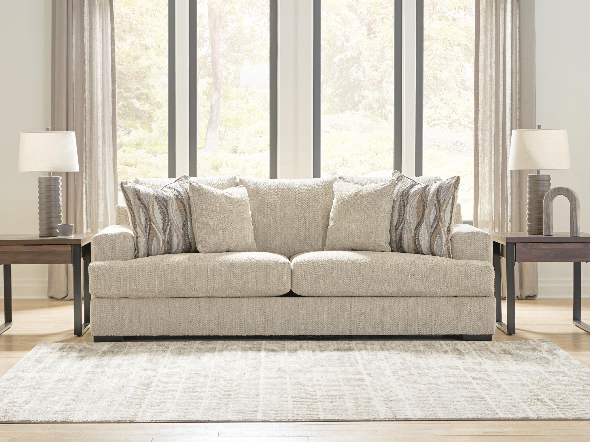 Beige upholstered sofa with striped accent pillows and three back cushions