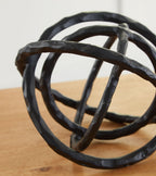 Barlee black abstract ring sculpture close-up, twisted loop bands