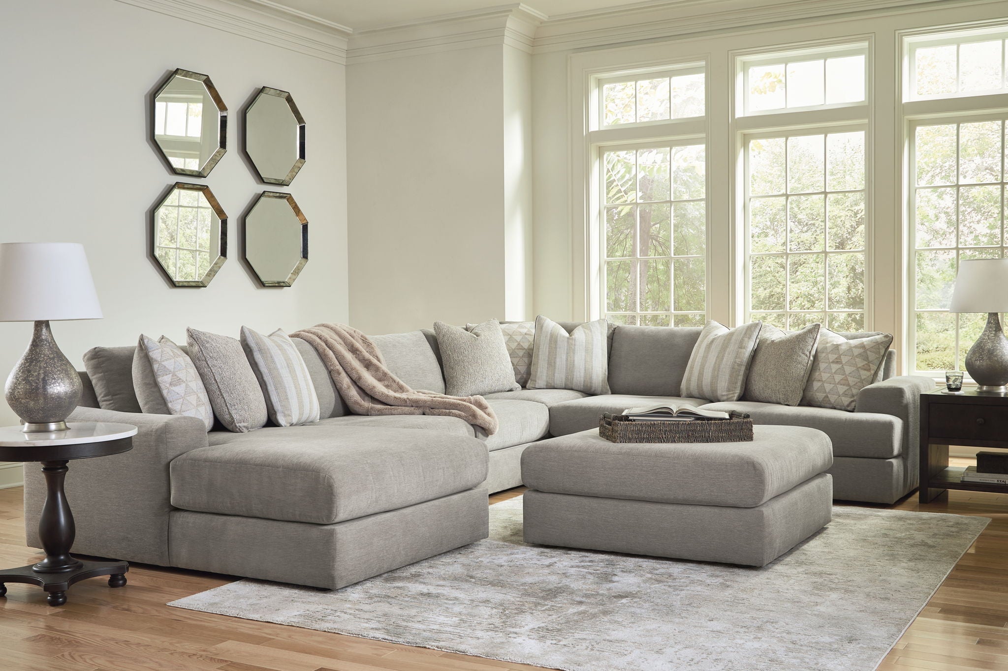Dark gray sectional with chaise ottoman and layered accent throw pillows