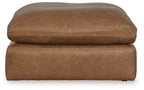 Light brown oversized accent ottoman with rounded top, stitched edges, and low base