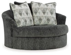 Dark gray oversized swivel accent chair with two white-and-black patterned cushions