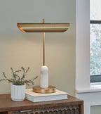 Rowleigh marble desk lamp on desk with gold shade and white marble base