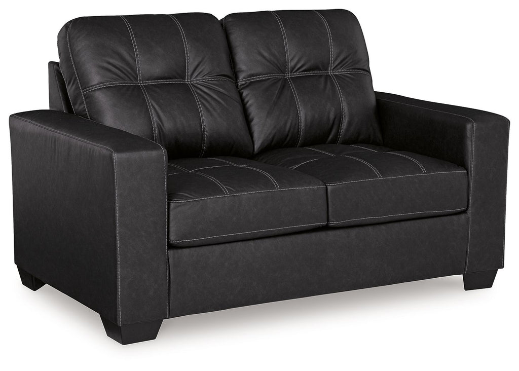 Black loveseat with tufted back, padded arms, and cushioned seat panels