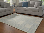 Light blue area rug with repeating grid pattern and subtle bordered edge