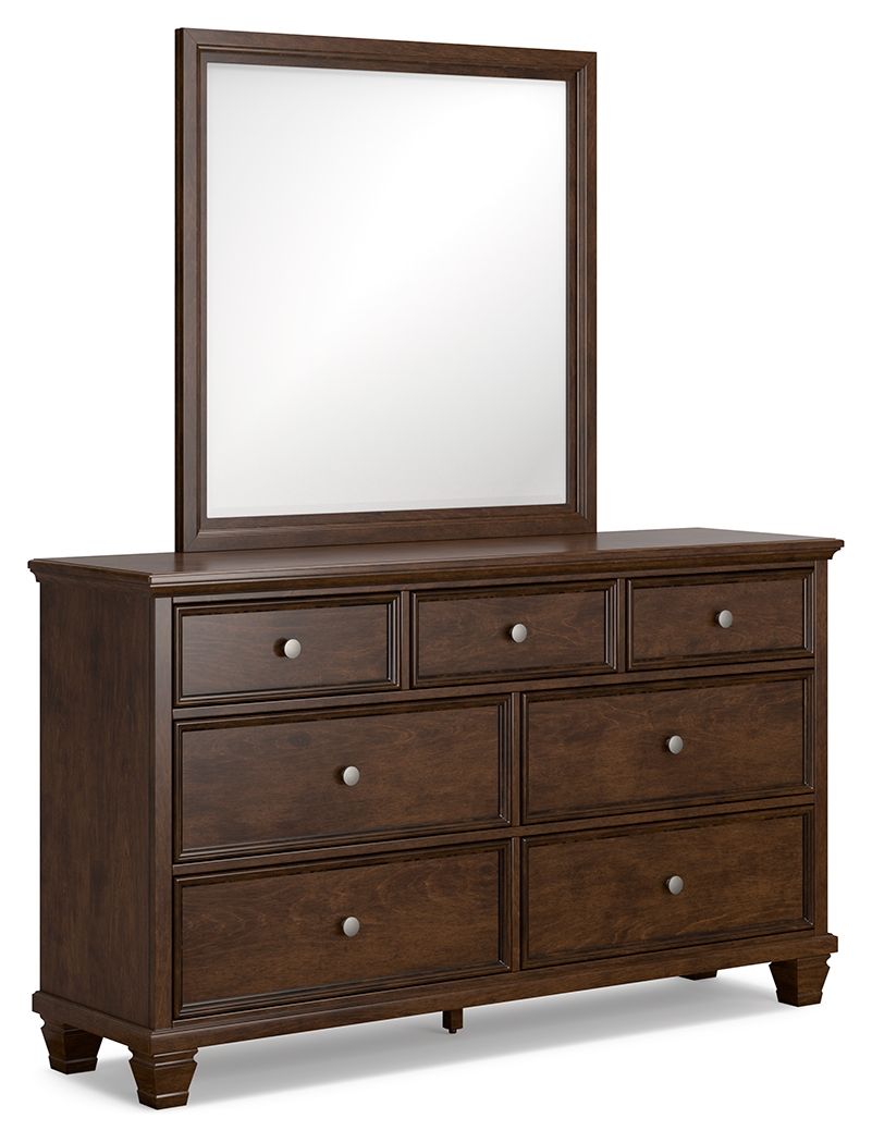 Brown dresser with attached framed mirror and six drawers, round metal knobs.