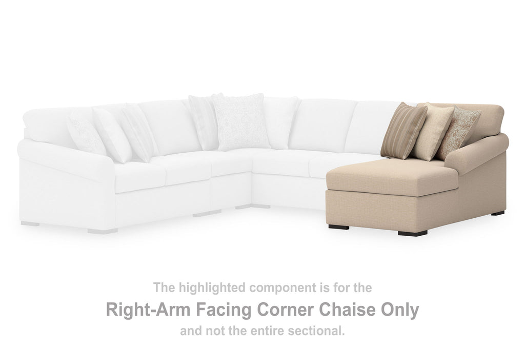 Right-arm facing beige corner chaise section with two throw pillows and black feet