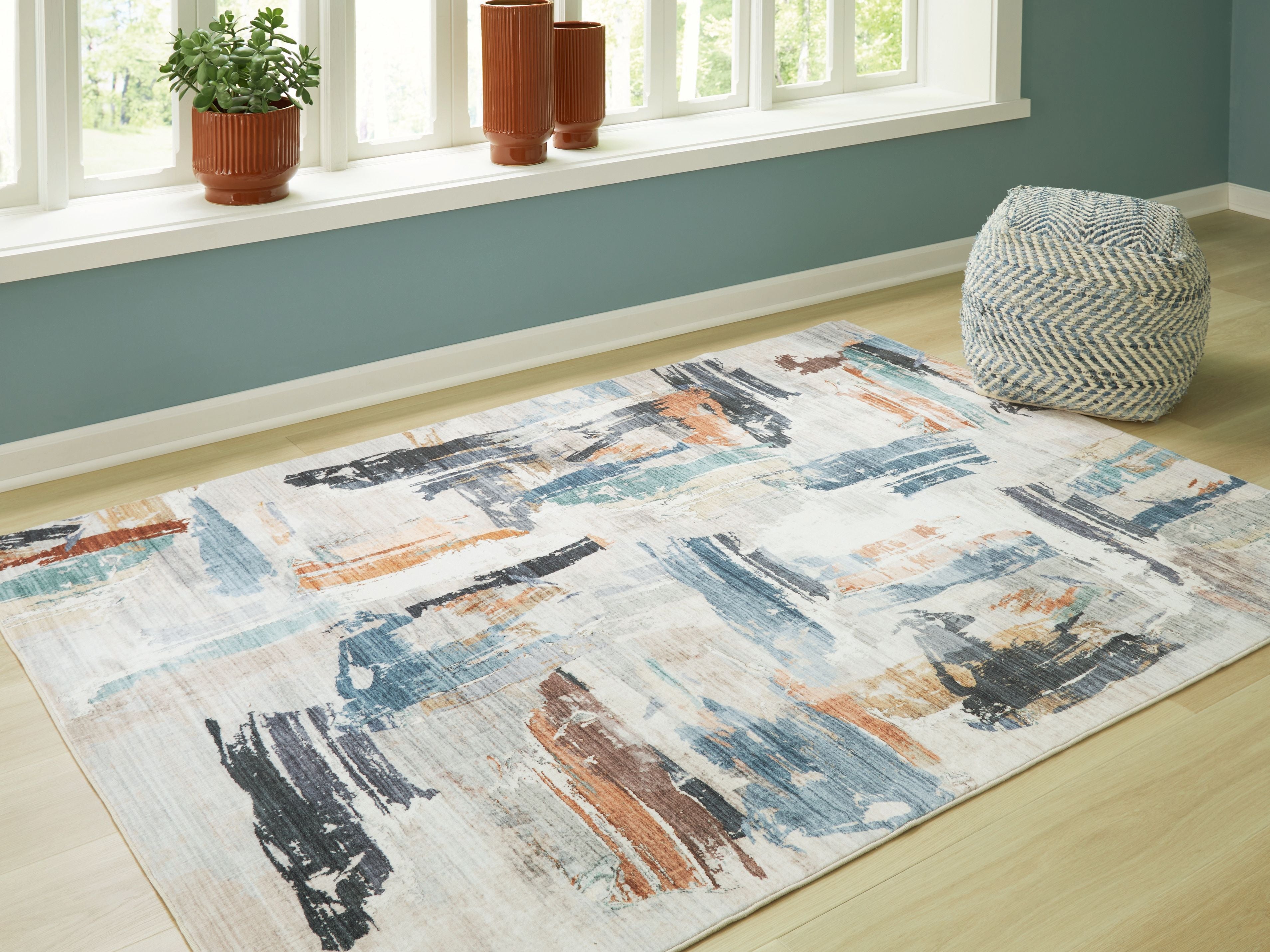 Washable rug with rectangular abstract design in beige, blue, and rust tones