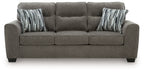 Dark gray fabric sofa with tufted back, square arms, and striped throw pillows