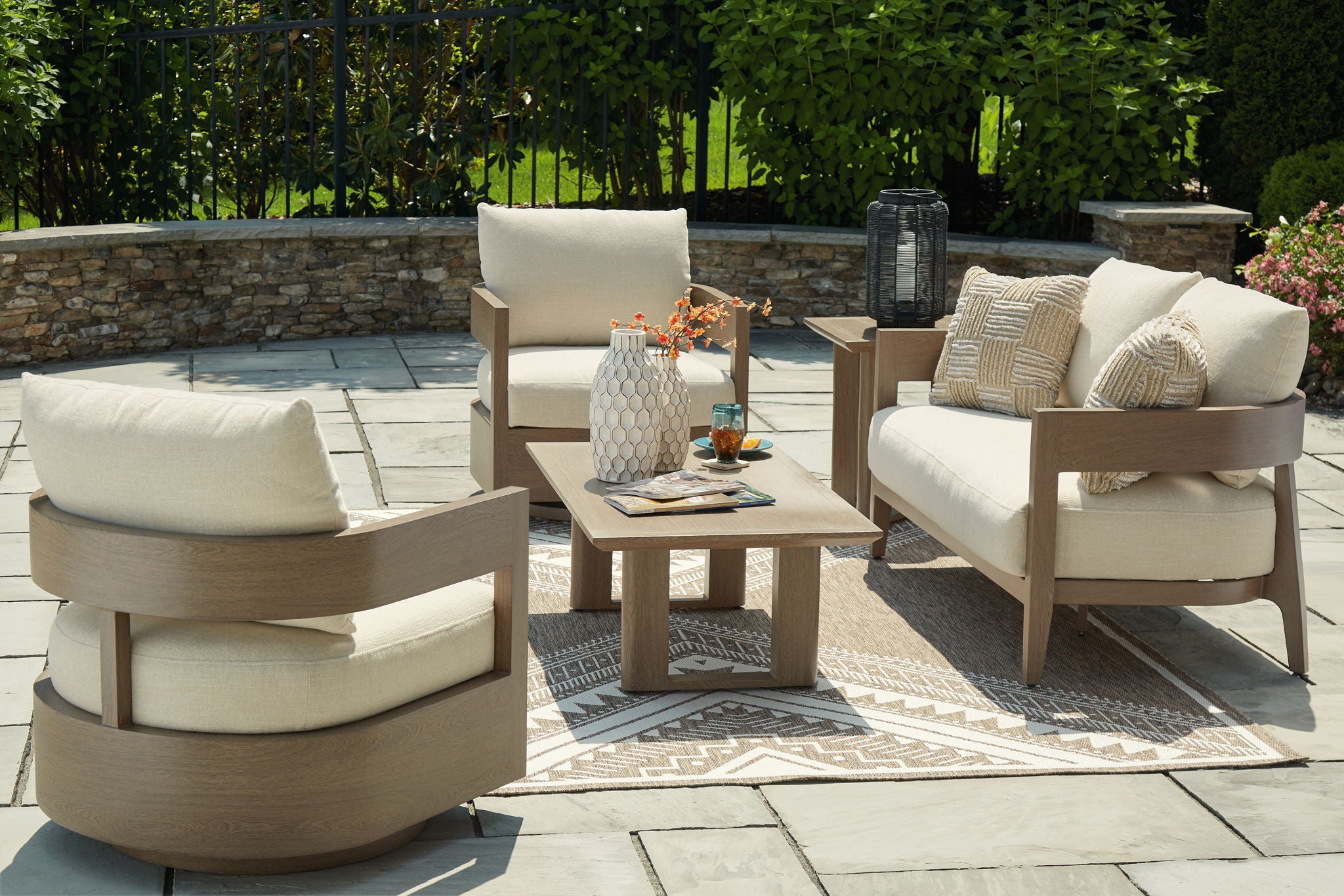 Outdoor lounge seating set with beige cushions, patterned pillows, and wood side table