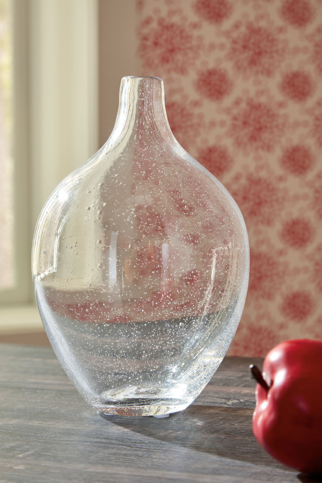 Clear glass vase with speckled finish and narrow neck, placed on a tabletop.