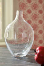 Clear glass vase with speckled finish and narrow neck, placed on a tabletop.