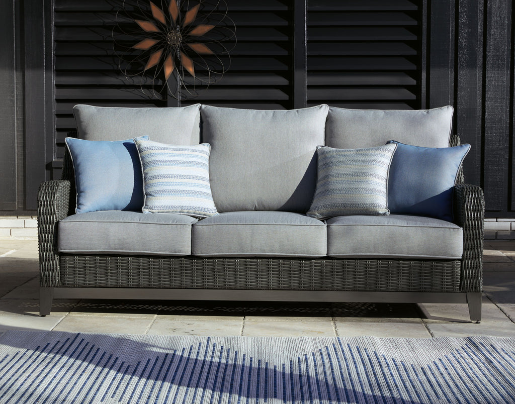 Gray woven outdoor sofa with gray back cushions and light blue striped pillows