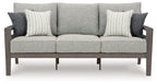 Gray outdoor sofa with three seat sections and two striped throw pillows on back