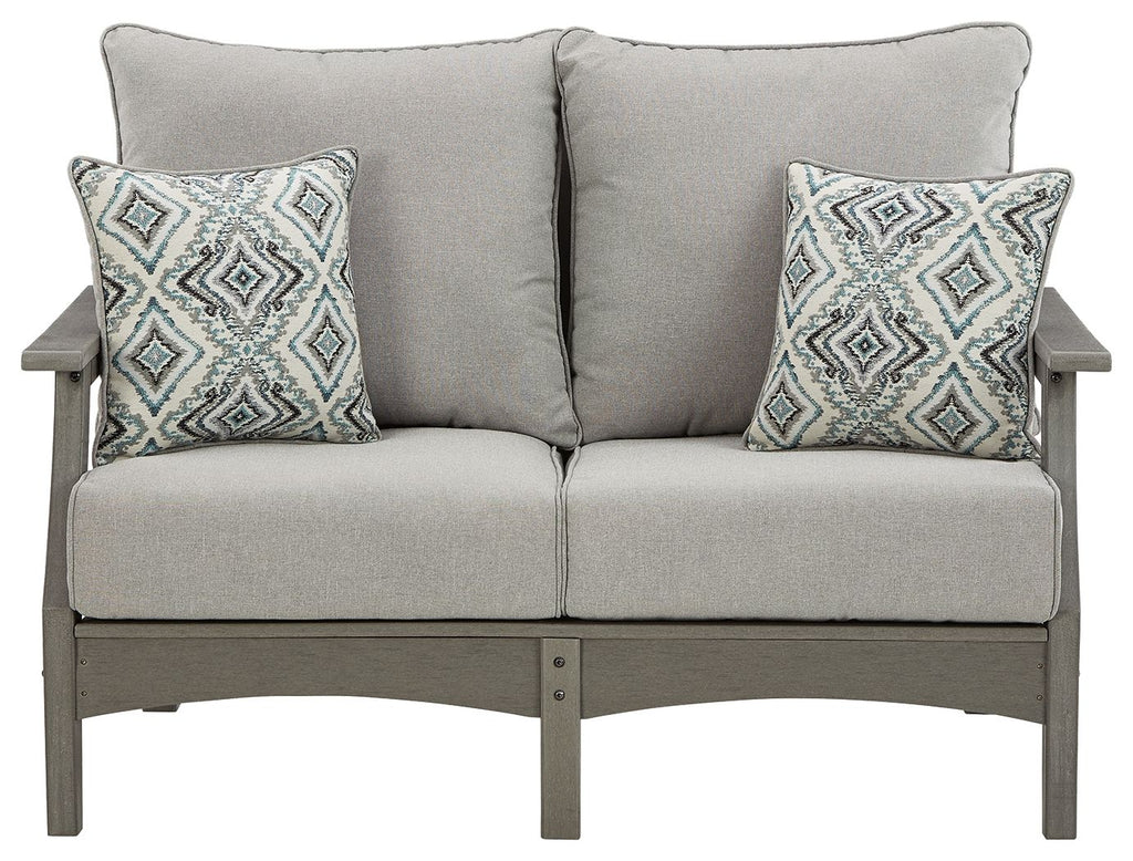 Gray upholstered loveseat with two diamond-pattern throw pillows and square armrests.
