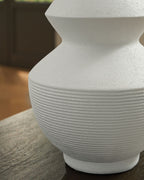 White ceramic vase close-up showing ribbed midsection and flared neck