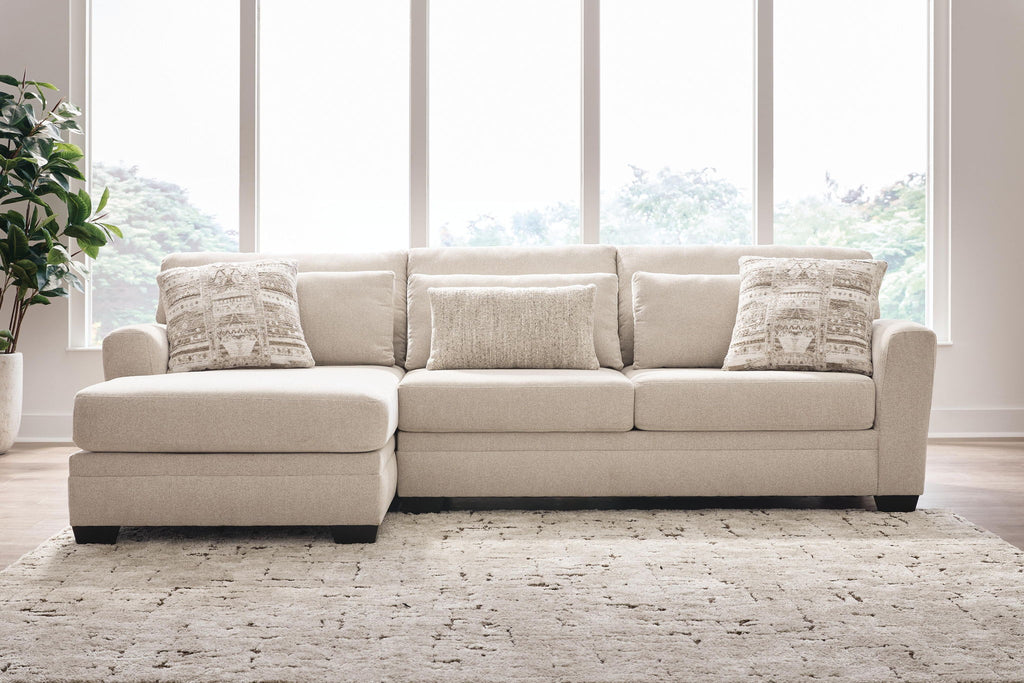 Light beige sectional sofa with chaise, square arms, and three throw pillows