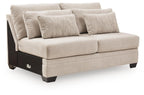 Armless loveseat with light beige fabric, square arms, and two throw pillows