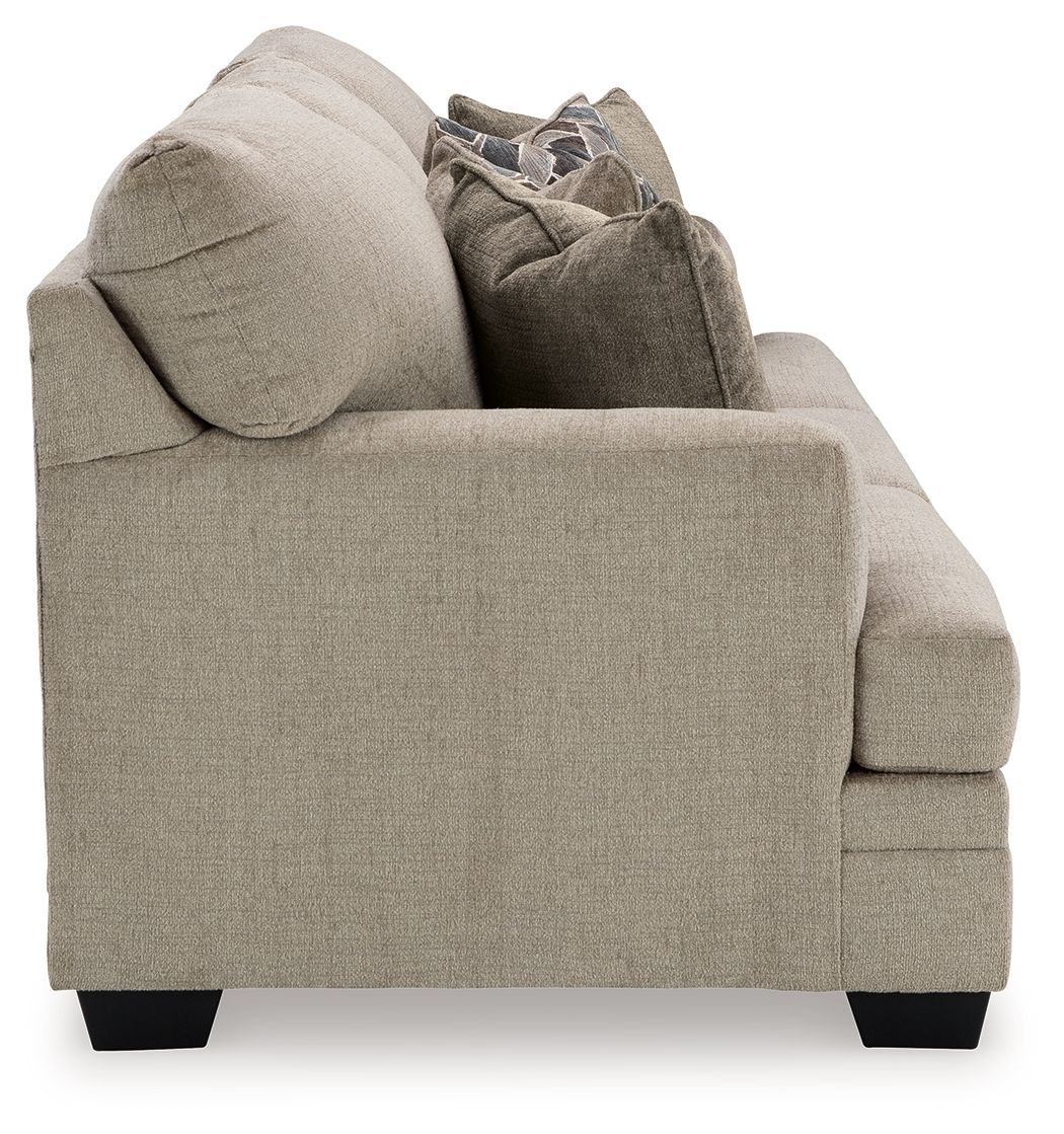 Stonemeade sofa in light taupe fabric, showing arm and back with accent pillows