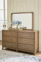Light brown dresser with large mirror and 6 drawers, styled top with decor