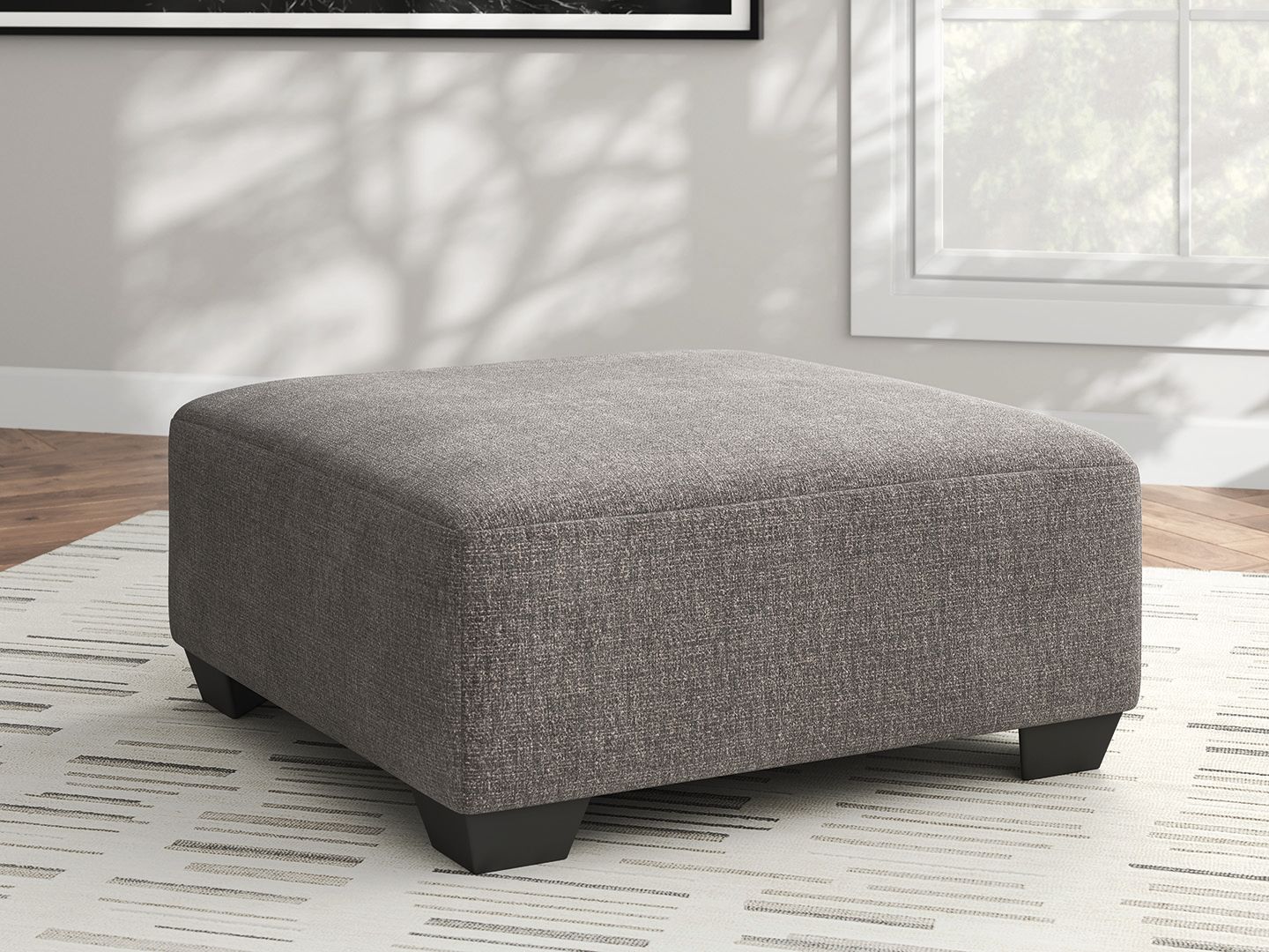 Square upholstered ottoman in heathered gray with low dark legs