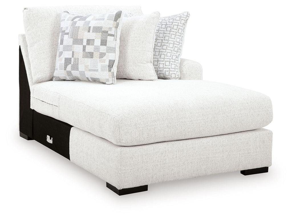 Corner chaise lounge in chalk fabric with patterned throw pillows and black legs