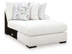 Corner chaise lounge in chalk fabric with patterned throw pillows and black legs