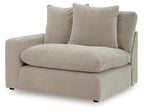 Light beige upholstered corner chair with large back pillow and deep seat