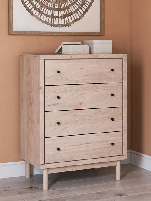 Four-drawer chest on tapered legs, light tan wood with black round knobs